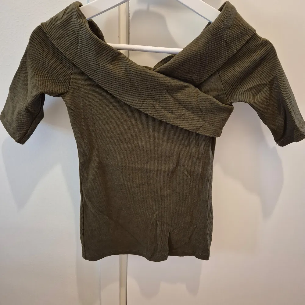 Khaki/Olivgrön Off-shoulder tröja från Gina Tricot. Nyskick, använd en gång. Stretchbar, mjuk och skön material. Storlek S. 95% bomull, 5% elastan.. Tröjor & Koftor.