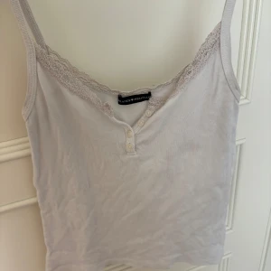 Brandy Melville topp - Vit Brandy Melville topp, den har en deo fläck men den syns knappt som man kan se på bilderna men annars så är den i jättebra skick!💗