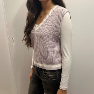Lila stickad väst - Fin lila väst med vita detaljer! Använd endast ett par gånger men tyvärr är den för liten!