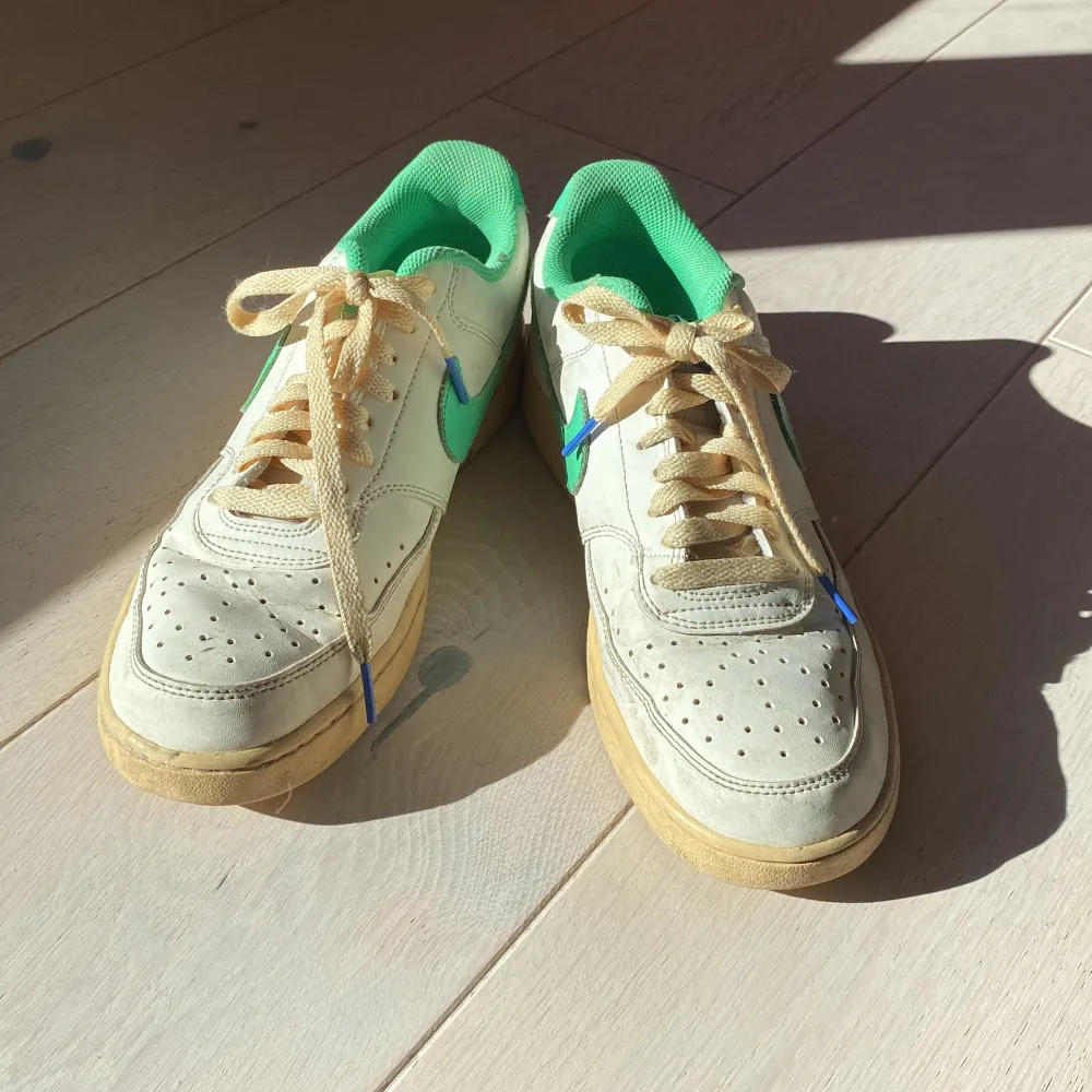 Vita sneakers med gröna detaljer. Väl använda, lite creasade men funkar fortfarande som skor. Skor.