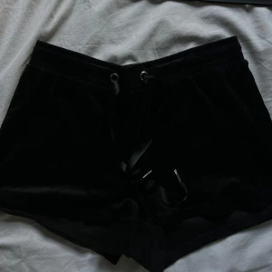 Svarta shorts från Gina Tricot - Säljer ett par snygga svarta shorts från Gina Tricot. De är gjorda i ett mjukt material och har en bekväm passform med snörning i midjan. Perfekta för en avslappnad dag eller en mysig hemmakväll.