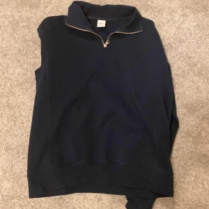 Mörkblå tröja med dragkedja från Zara - Snygg mörkblå tröja från Zara med halv dragkedja och hög krage. Perfekt för kyligare dagar. Tröjan har långa ärmar och en stilren design.