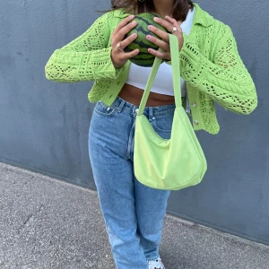 Grön stickad kofta från Zara - Säljer en snygg grön stickad kofta från Zara med knappar framtill. Koftan har ett fint hålmönster och långa ärmar, perfekt för lager-på-lager-stil. Den är både trendig och bekväm.