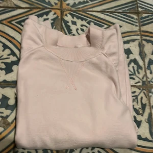 Ljusrosa sweatshirt - Säljer en ljusrosa sweatshirt med rund hals och ribbade muddar. Perfekt för en avslappnad stil.