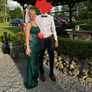 Grön glittrig balklänning - Säljer min balklänning, använd en gång och är som ny skick, de är storlek 36 men jag brukar pendla mellan 36 och 34 så skulle säga de passar båda 