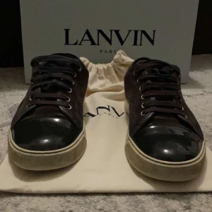 Lanvin cap toe - Snygga sneakers från Lanvin med fina detaljer och snörning. Skorna har en stilren design med en kombination av mocka och skinnmaterial. Perfekta för en trendig look. UK6