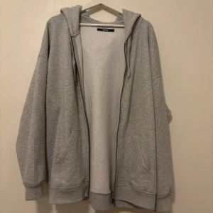 Grå hoodie från Bik Bok - En grå hoodie från Bik Bok i storlek S. Den har en dragkedja framtill, är overzised