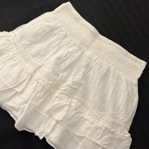 Vit volangkjol från Gina Tricot  - En gullig vit kortkjol med volanger från Gina Tricot i storlek S.