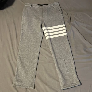 Thom browne Byxor - Snygga Thom Browne byxor i färgen grå. De har en rak passform och är tillverkade i ett mjukt material. Byxorna har hällor för bälte. Storlek 0=Xs