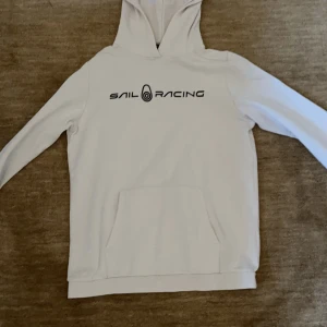 Sail Racing hoodie - Vit hoodie från Sail Racing med logga på bröstet. Hoodien är i storlek S men passar även M. Säljs då den inte används.