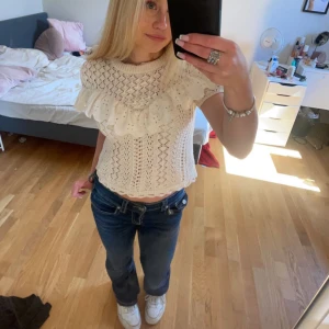 Zara  blus med volangdetaljer - Charmig vit stickad blus med korta ärmar och vackra volangdetaljer över bröstet. Perfekt för en söt och stilren look. SKRIV INNAN KÖP!❤️❤️