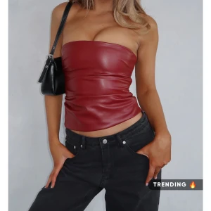 Röd tubtopp i skinnimitation från White Fox - Snygg röd tubtopp i skinnimitation från White Fox. Perfekt festtopp. Köpt för 45$ alltså ca 500kr! Ny med lapp! 