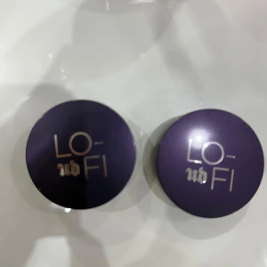 Lo-Fi Lip Mousse i nyanserna Fade och Echo - Två Lo-Fi Lip Mousse från Urban Decay i nyanserna Fade och Echo. Fade är en varm brun ton medan Echo är en djup plommonfärg. Förpackningarna är kompakta och inkluderar en spegel för enkel applicering.