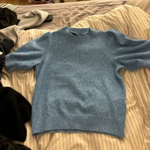 Blå stickad tröja från Vero Moda - Säljer en mysig blå stickad tröja från Vero Moda. Tröjan har en rund halsringning och långa ärmar, perfekt för kyligare dagar. Den är mjuk och bekväm, idealisk för både vardag och avslappnade tillfällen.