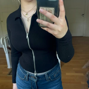 Långärmad tröja med dragkedja  - Långärmad tröja med dragkedja så man kan välja hur den ska sitta. Ny aldrig använd bara provad.