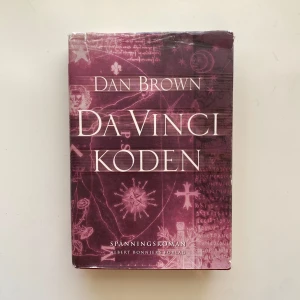 Da Vinci-koden - Den bästsäljande och spännande romanen av Dan Brown om en mystisk historia som utspelar sig i Paris och London. Boken är i gott skick (själva boken är nära nyskick, skyddsomslaget är i gott skick).  Boken är i hardback (inbunden). Språk: Svenska