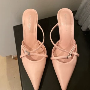 Klackskor med rem - Ljusrosa klackskor från Public Desire i storlek 36, klacklängd ca 8 cm. Använd fåtal gånger. Mycket bekväma.