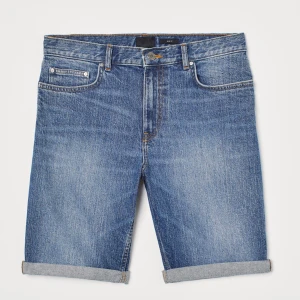 Blå jeansshorts - Säljer ett par klassiska blå jeansshorts i regular fit. De har en snygg uppvikt kant och stängs med dragkedja och knapp. Perfekta för sommardagar eller avslappnade tillfällen. 🕶️