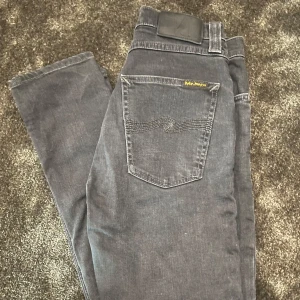 Svarta jeans från Nudie Jeans - Säljer ett par svarta jeans från Nudie Jeans. De är slim fit och har en dragkedja. Perfekta för både vardag och fest! 