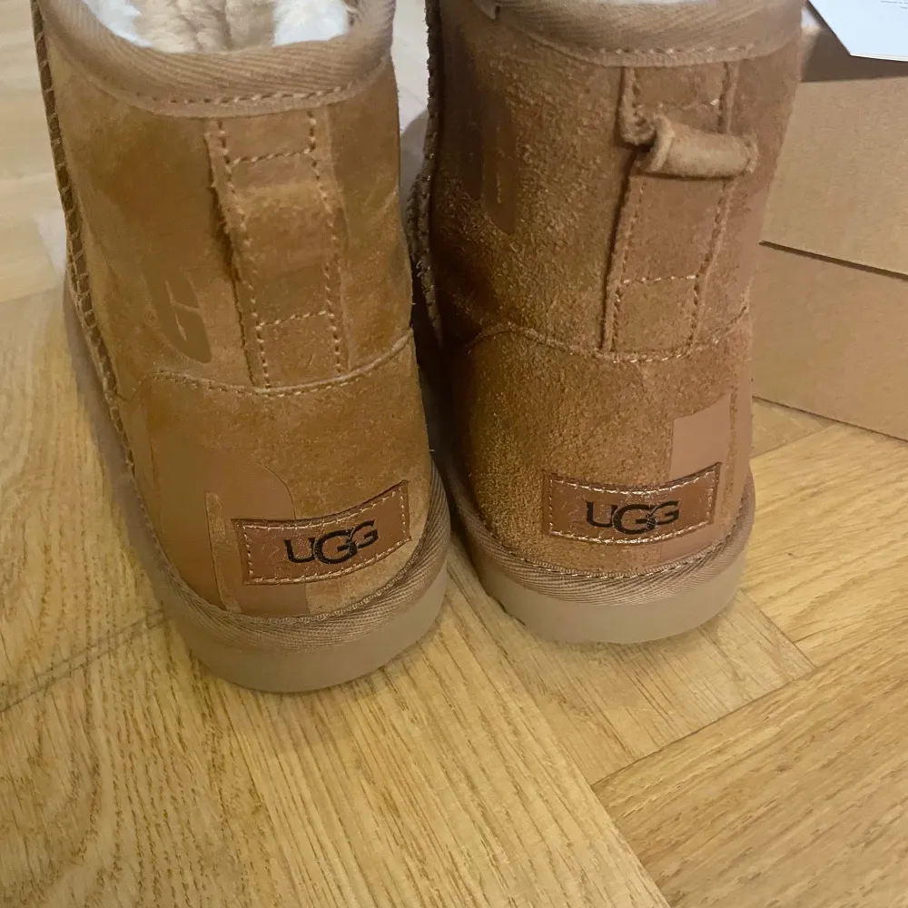 Säljer ett par UGG Kids Classic Mini Scatter Graphic stövletter i beige/brunt. Storlek 36.   Skorna är helt nya och har aldrig använts, se bilder! Mycket snyggt och diskret mönster. Naturligtvis äkta och köpta på Foot locker.. Skor.