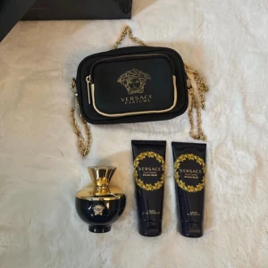 Versace Pour Femme Dylan Blue Parfymset - Säljer ett lyxigt parfymset från Versace, Pour Homme Dylan Blue. Setet kommer i en elegant svart och guld förpackning med detaljerade mönster. Innehåller en parfymflaska och matchande accessoarer. Perfekt present eller för att skämma bort dig själv! 💛