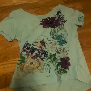 Turkos tshirt med blommor - Söt med blommor och rinestones klippt i halslinningen💕