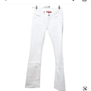 Vita bootcut jeans från Gina Jeans - Snygga vita bootcut jeans från Gina Jeans med låg midja och klassisk femficksdesign. Perfekta för en stilren look. De har en knapp och dragkedja framtill. Midjemått:70cm