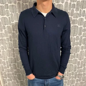 Burberry 100% merino - Säljer denna långärmade pikén ifrån burberry i 100% merinoull. Skicket är perfekt och det finns inga defekter. Vid fler funderingar skriv i dm.