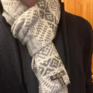Loro piana kashmir scarf - Snygg och varm halsduk från Loro piana  med 85% Kashmir och 15% silke ett stilrent mönster i ljusgrått och mörkgrått. Perfekt för kyliga dagar och ger en elegant touch till din outfit. 