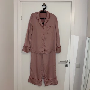 Rosa satinpyjamas H&M - Härlig silkesles och svalkande satinpyjamas från H&M i storlek 36.  Lite lång på mig som är 161 cm (ca 5 cm för lång), så perfekt för långa personer. Känns lyxig och skön att ha på sig. 