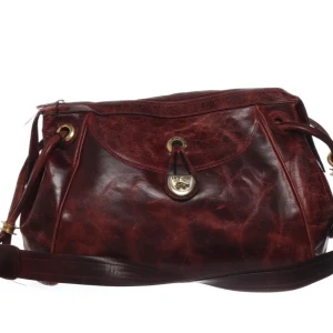 Vinröd axelväska i skinn -  vinröd axelväska i skinn med dragkedja och dekorativa detaljer i metall. Väskan har en  axelrem och dragkedja. Märket är La Tortue, finns defekter men gott skick Bredd:34cm Djup:15cm Höjd:25cm Skicka gärna prisförslag! 