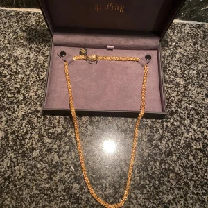 Guldhalsband i elegant design - Snyggt guldhalsband med intrikat flätad design, perfekt för att ge en touch av elegans till din stil. Levereras i en stilren ask. 60 cm och 4 mm. Levereras idag av kejsar.se