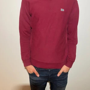Vinröd tröja från Lee - Säljer en stilren vinröd tröja från Lee med liten logga på bröstet. Tröjan har långa ärmar och en bekväm passform, perfekt för vardagsbruk. Den är tillverkad i ett mjukt material som håller dig varm under kyligare dagar.