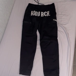 Svarta byxor från Hoodrich - Snygga svarta byxor från Hoodrich med tryck på både fram- och baksida. Byxorna har en normal passform 