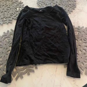 Svart långärmad topp från 157 - Säljer en svart långärmad topp från 157 i bomull och elastan. Perfekt för en stilren look. Toppen har en enkel design och är bekväm att bära.