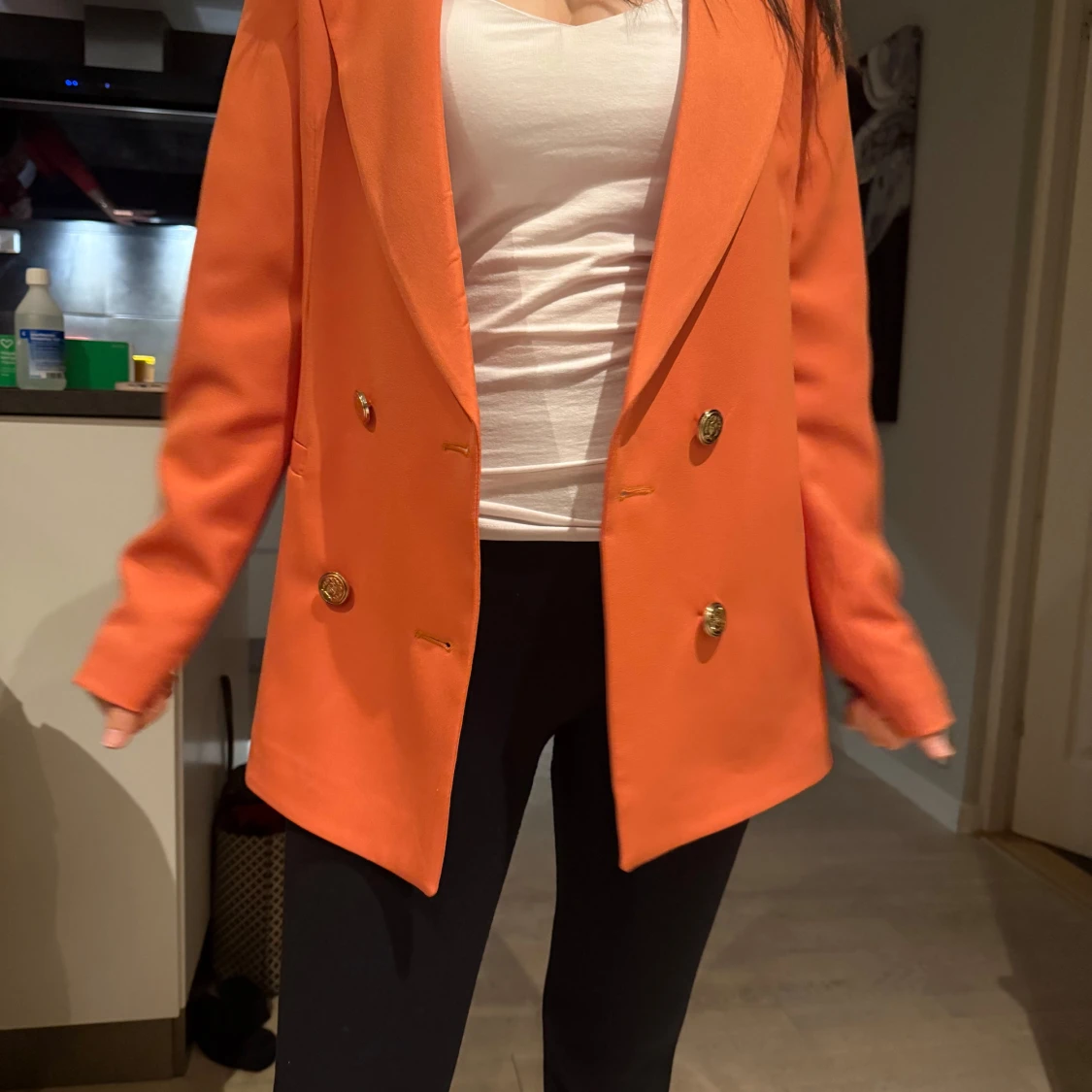 Orange kavaj med guldknappar