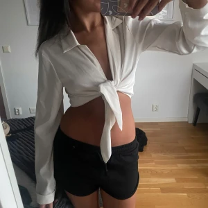 Vit topp med knytdetalj - skjorta som man knyter i fram. Sitter jättefint på och är såå bekväm 🤍🤍 
