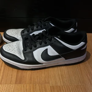 Svartvita Nike sneakers - Säljer ett par panda dunks, rätt använda men tvättar man dem och fixar creasing så blir dem rätt bra. mest använda inomhus fast en del utomhus. undersidan är i väldigt bra skick. 