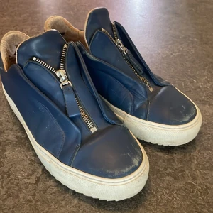 Axel Arigato skor - Hej! Säljer nu mina axel arigato i storlek 41 men funkar även jättebra till 42. Dem är i ett bra skick, lite smutsiga där fram o en liten slitage vid hälen på insidan som man inte märker av. Hör av dig om du har några frågor!