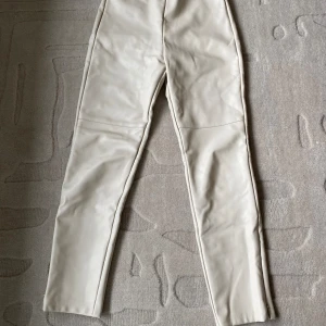 Skinnbyxor (barn) - Ett par beiga skinnbyxor med tragkedja längst ner. De är från Zara och är för flicka 11-12 år (152 cm).