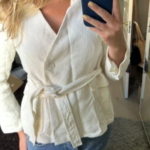 Krämvit jacka - Krämvit eller vit jacka/ kofta omlottkofta med knyte och knappar, kort kappa sommarjacka
