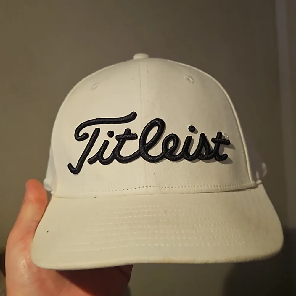 Säljer en snygg vit keps från Titleist i storlek S/M. Kepsen har en broderad logga framtill och baktill, vilket ger den en stilren look. Den är gjord i ett flexibelt material för en bekväm passform. Perfekt för golf eller andra utomhusaktiviteter! Kepsen är helt ny, endast använd en gång och trivdes inte i den. . Accessoarer.