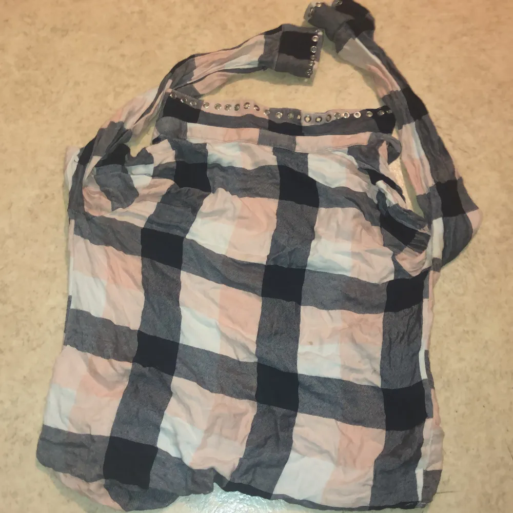 Säljer en rutig skjorta från H&M i mjuka toner av rosa, blått och beige. Skjortan har långa ärmar och knappar framtill. Perfekt för en avslappnad stil med en touch av elegans. Passar bra till jeans eller kjol för en trendig look.. Paidat.