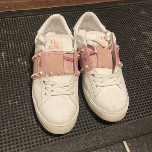 Vita sneakers med rosa detaljer - Snygga vita sneakers från Valentino med unika rosa detaljer och nitar. Skorna har en klassisk snörning och en bekväm sula. Perfekta för att ge en stilren touch till din outfit. Knappt använt. Jätte bra skick tvättar tills de innan de fraktas. Köparen står för frakten💞snabb leverans. Passar till allt. Speciellt till sommaren🥳☺️vill få de sålda då jag inte använder de längre😁💞