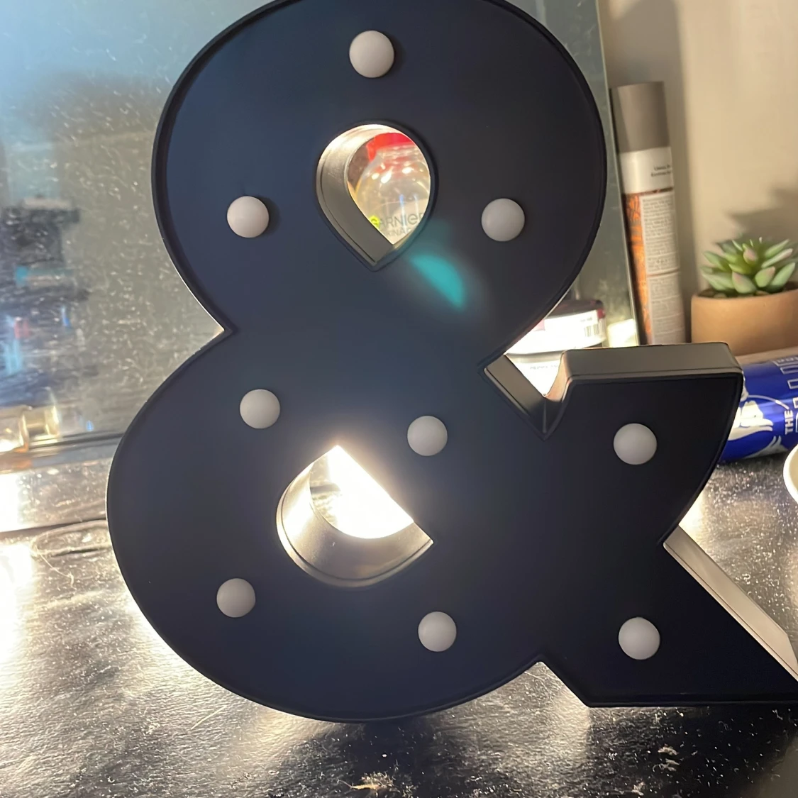 Svart dekorationslampa i form av ett &-tecken