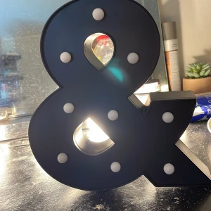 Svart dekorationslampa i form av ett &-tecken - Snygg och modern dekorationslampa i form av ett &-tecken. Lampan är svart med vita ljuspunkter och ger ett stilrent intryck. Perfekt för att ge rummet en unik touch. Kan placeras på hyllor eller bord för en cool effekt. Den är helt ny och helt oanvänd!❤️