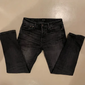 Svarta jeans från Jack & Jones - Snygga svarta jeans från Jack & Jones i modellen Tapered Mike. De har en modern tapered passform. De är storlek 30/32, säljer då de är lite stora på mig som är ca 180cm. Nypris 899kr. Tveka inte att ställa frågor!