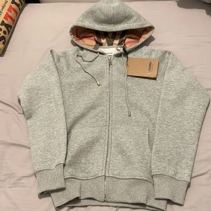 Grå hoodie från Burberry - Halt ny säljer den för min leverantör skickade fel storlek och modell. Storleken är liten, S men passar XS endast 499 kr hör av er vid intresse! 