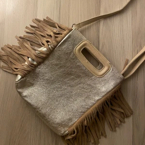 Maje style leather bag - Snygg guldig axelväska med fransar och praktiskt handtag.