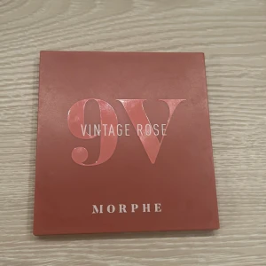 Morphe 9V Vintage Rose Ögonskuggspalett - Snygg ögonskuggspalett från Morphe med nio nyanser i rosa och bruna toner. Perfekt för att skapa både vardagliga och dramatiska looks. Inkluderar nyanser som 'Blossom', 'Retro Whoa' och 'Rose Bold'. Har fått den i en julkalender så har ej kvar någon orgibal förpackning men den är helt oanvänd inte testat eller något 